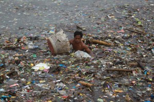 20120801 A man tries to recover salvageable materials from a sea of garbage pushed by strong waves to the Manila Bay as the country experience continuous monsoon rains. Photo by RemZamora