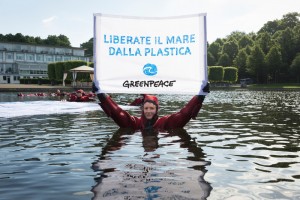 50 Greenpeace activists demonstrate for the protection of the oceans at the G20 Conference on Plastic Rubbish in Bremen. Representatives of the 20 most significant Industry and threshold countries meet to discuss ways to reduce the amounts of plastic rubbish in the oceans. Environmental activists in bright red survival suits form the letters ‘ACT’ together with a floating banner saying “for plastic free oceans” in a lake near the conference venue. Hand-Banner reads in Italian: "Liberate il Mare dalla Plastica!". 50 Greenpeace-Aktivisten demonstrieren fuer den Schutz der Meere vor der G20-Konferenz zu Plastikmuell in Bremen. Vertreter der 20 wichtigsten Industrie- und Schwellenlaender diskutieren auf Einladung der Bundesregierung Wege, wie sich die wachsende Menge Plastikmuell in den Meeren reduzieren laesst. Im See vor dem Tagungshotel formen die Aktivisten in Ueberlebensanzuegen schwimmend das englische Wort „ACT“, dazu ein Banner "For plastic-free oceans" (Fuer Plastikfreie Meere). Auf dem Handbanner steht in Italienisch "Fuer Plastikfreie Meere".